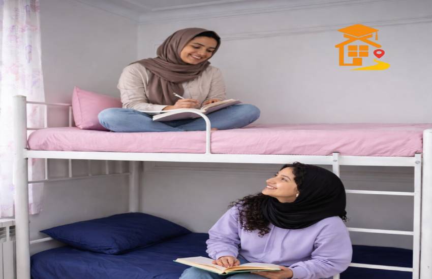 دو دانشجوی دختر در اتاق خوابگاهی روی تخت دوطبقه نشسته‌اند و در حال مطالعه و گفت‌وگو هستند.